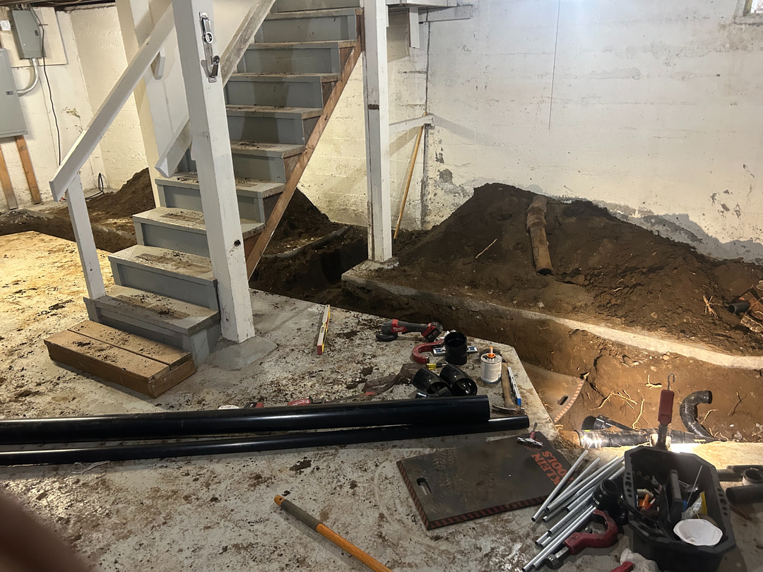 Basement excavation for a main line replacement, trench cut alongside the foundation
