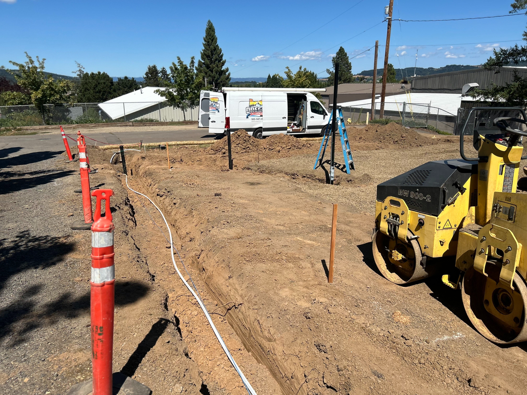 Oregon Plumbing van on a Newberg jobsite beside a freshly cut service trench