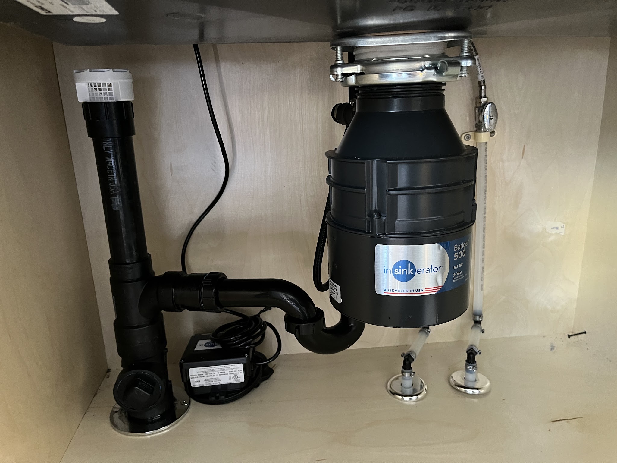 New disposal and drain assembly installed under a kitchen sink